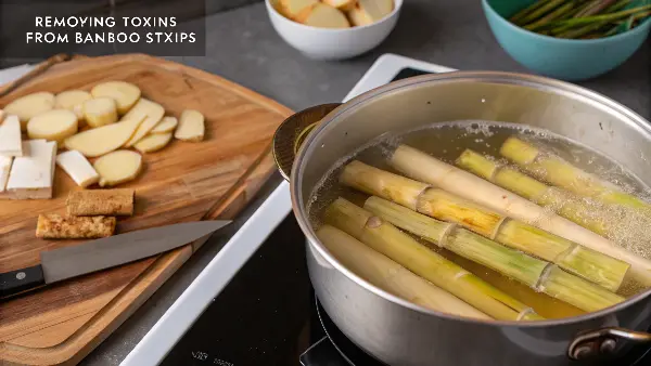 Bamboo shoots boiling in a pot of water on a stove