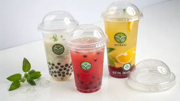 Eco-Friendly PLA Bubble Tea Cups Clear PLA bubble tea cups with dome lids, showing their transparency.