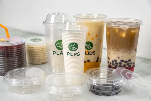 A clear PLA cup filled with colorful bubble tea, with a dome lid and a wide straw.