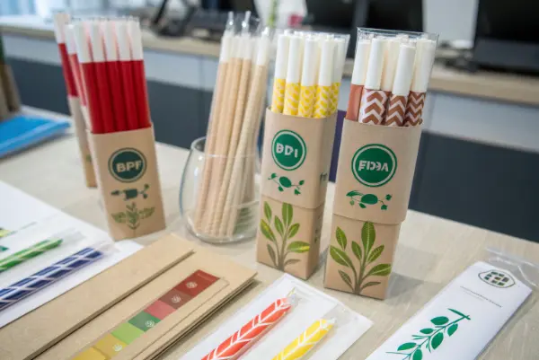 Custom-branded paper and PLA straws with company logos.