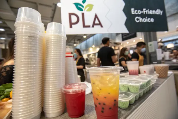 A side-by-side comparison showing the clarity of a PLA cup next to a traditional plastic cup.